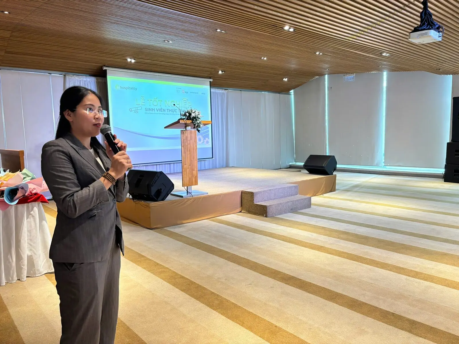 Loo nói vào mic trước sân khấu hội trường